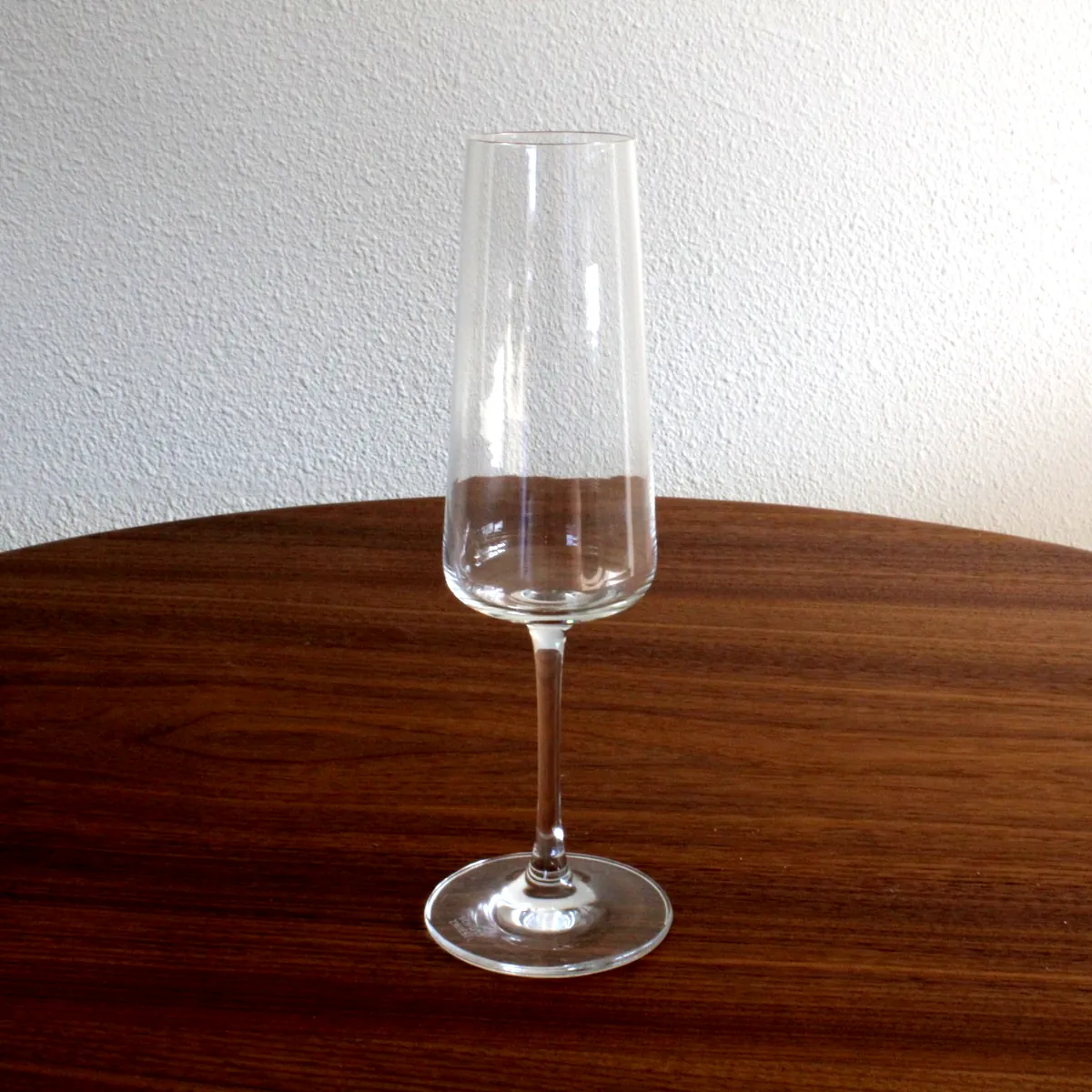 Champagneglas met slanke kelk op houten tafel