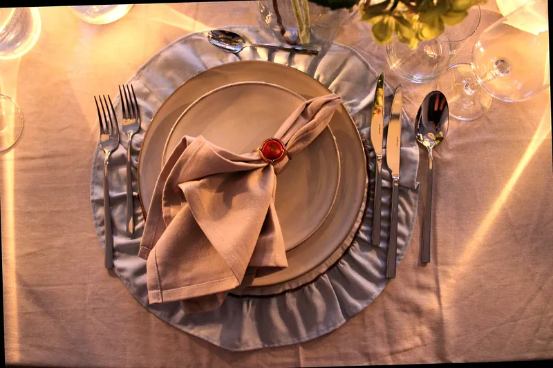 Gedekte tafel voor een 21-diner met glaswerk, servetten en tafellampen