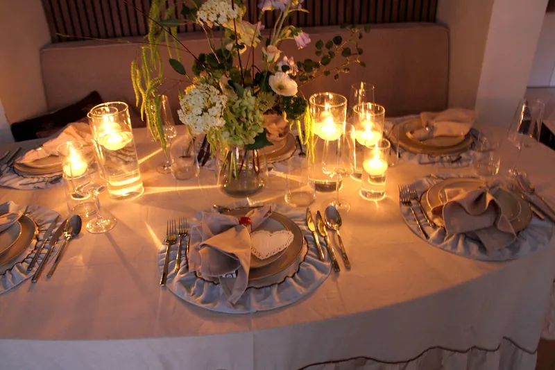 Gedekte tafel voor een verjaardagsjubileum met linnen servetten en zijdebloemen